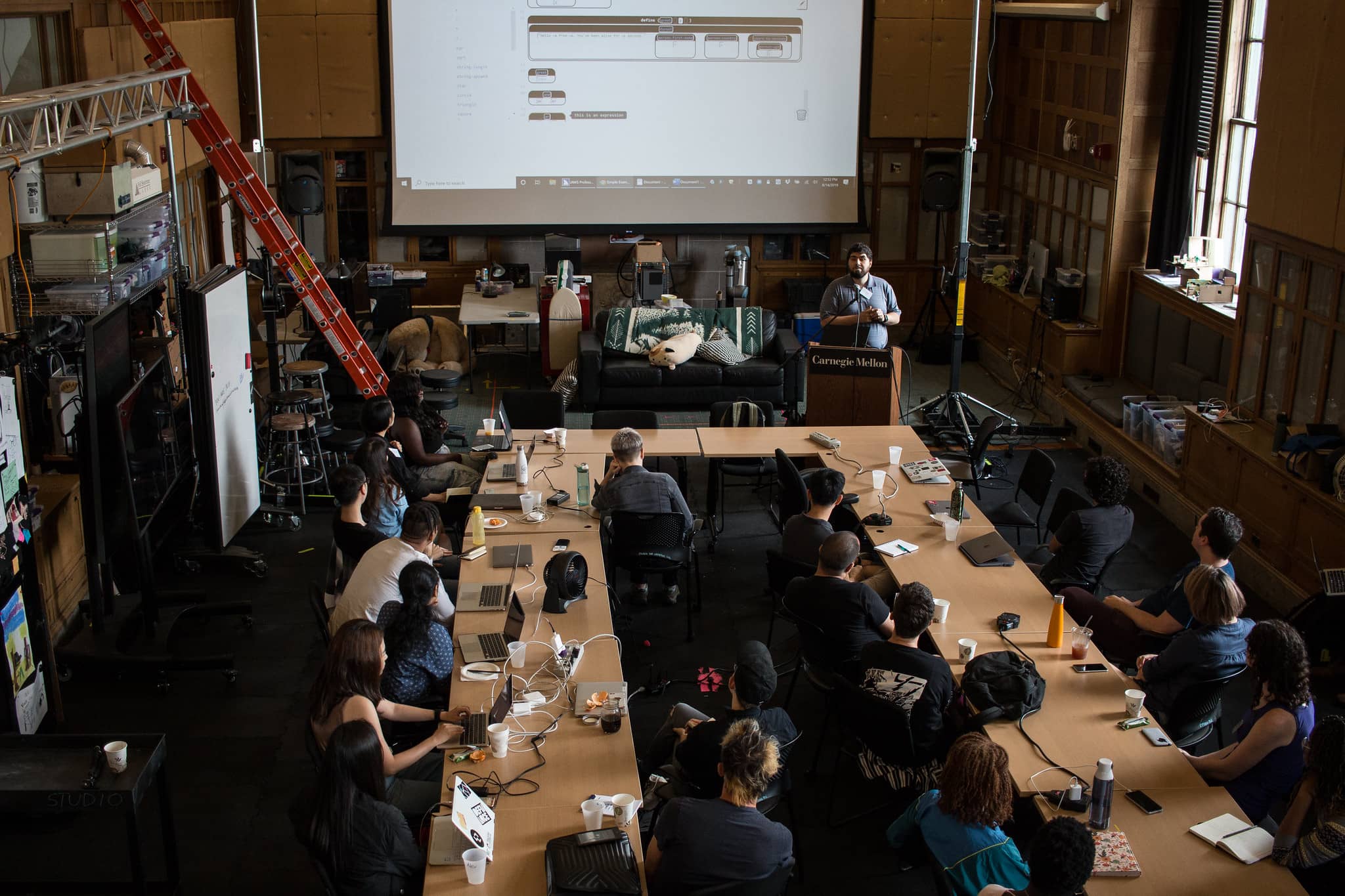 Man at a podium giving a presentation to the group