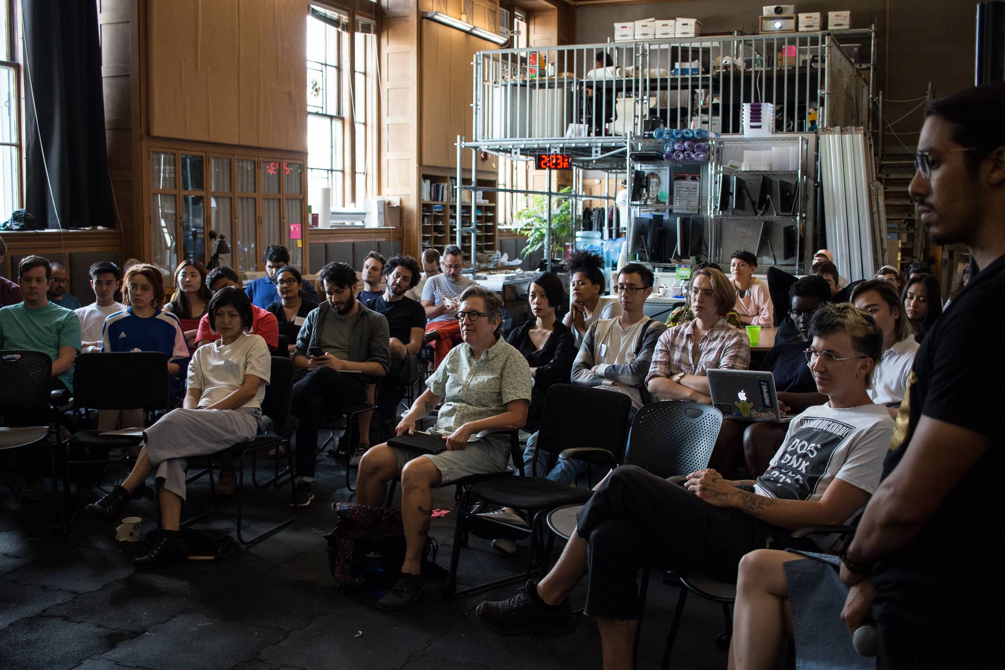 Participants sit in a classroom towards the speakers listening intently