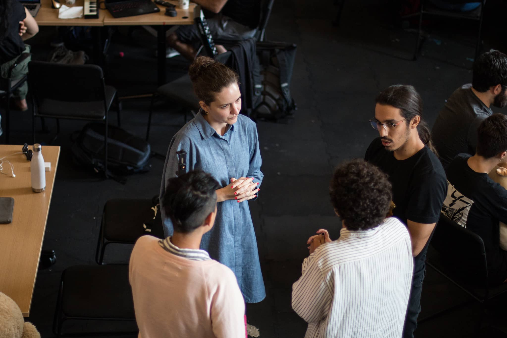 Four participants standing in a circle conversing