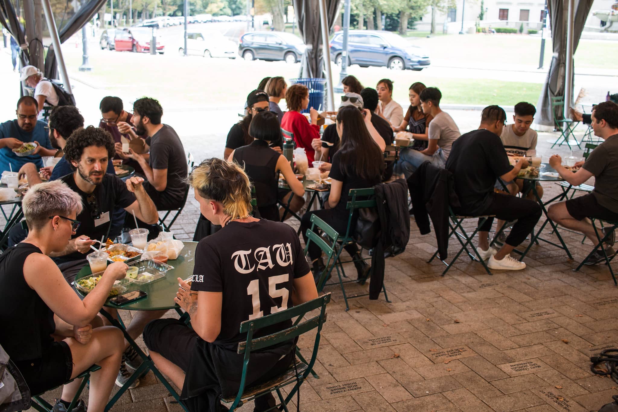 Participantes almorzando juntos sentados al aire libre"